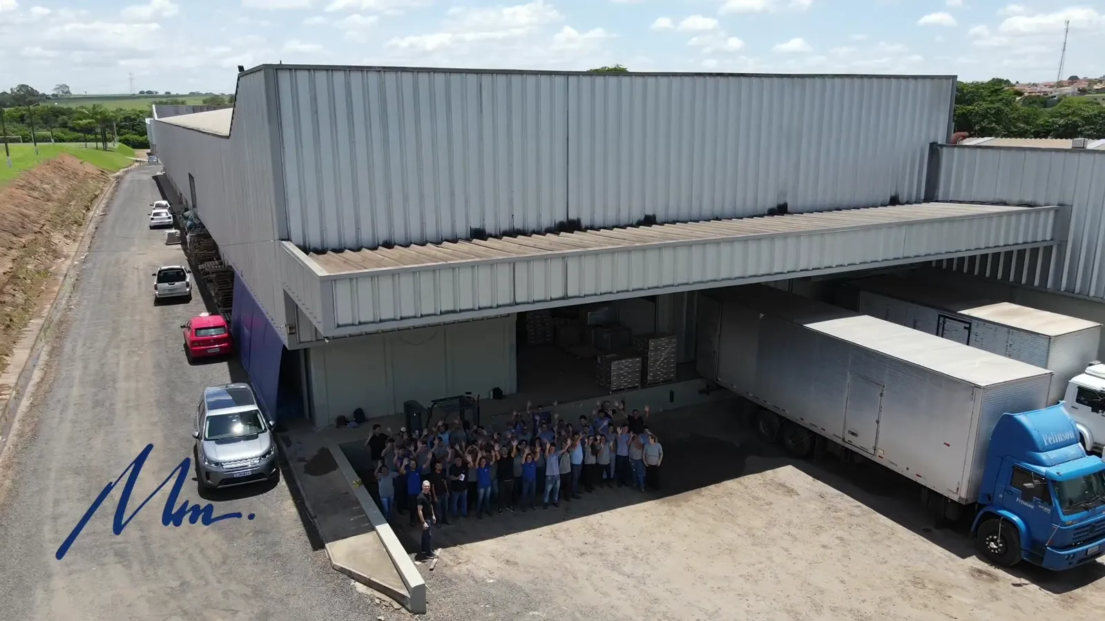Equipe da Mania de Móveis em frente à fábrica